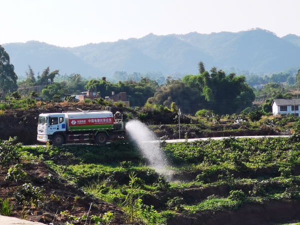 項目建設中,中國電建組織渝西項目部協助澆灌農作物-郭正祥 攝.jpg